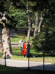 Un couple joue de la contrebasse au parc