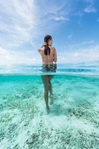 Une femme qui a bien bossé son summer body se baigne nue dans la mer