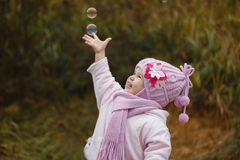 Une petite fille joue avec des bulles de savon