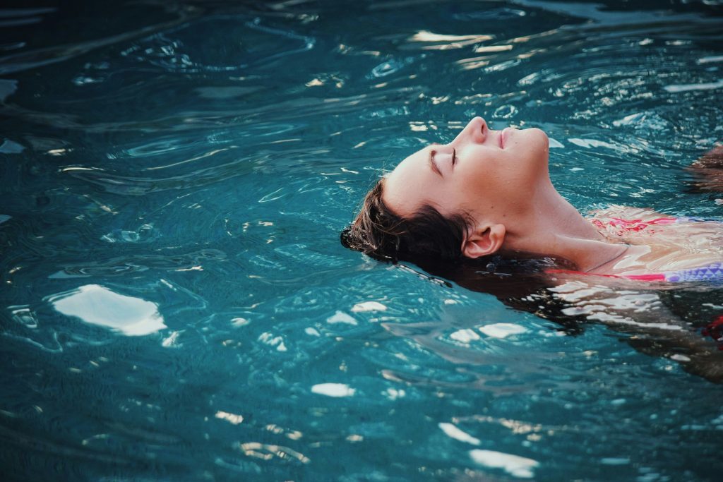 Une femme flotte dans l'eau, sereine