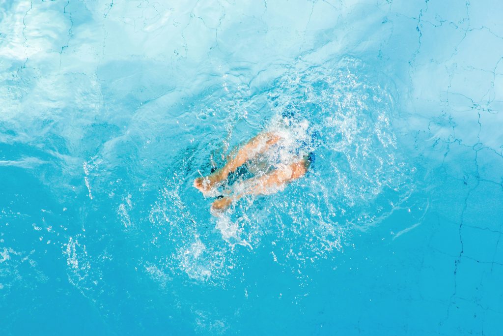 Un enfant joue dans l'eau, seules ses jambes sont visibles