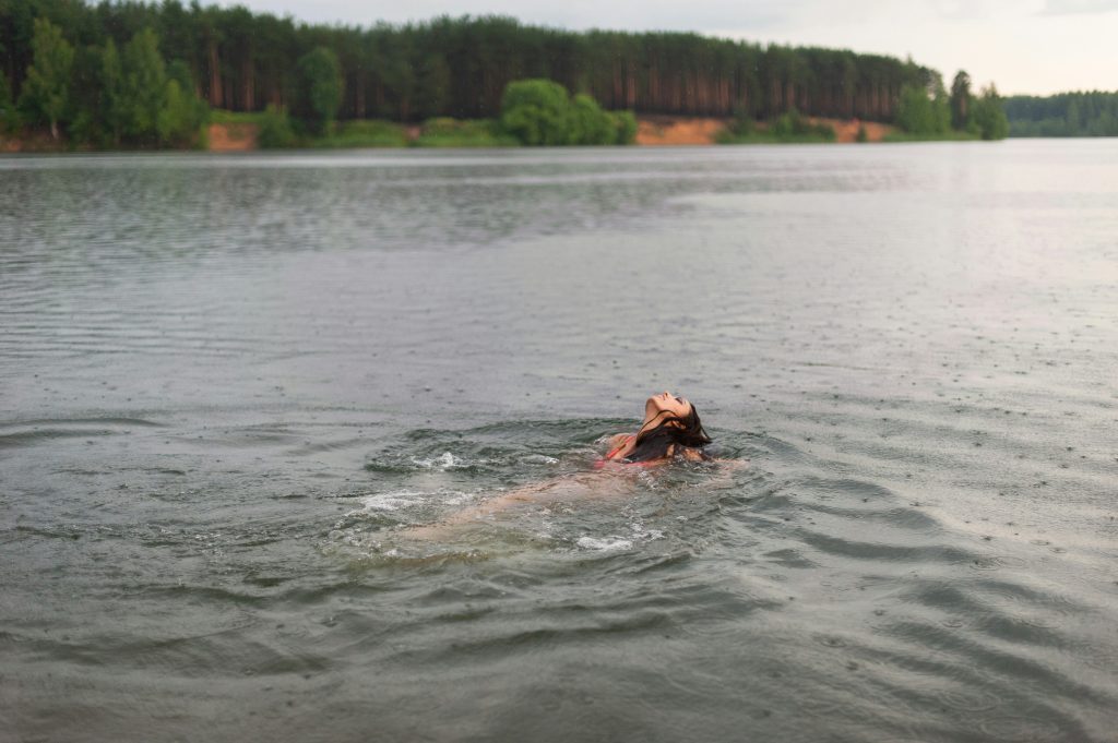 Nager à contre-courant, une femme nage dans une rivière sous la pluie