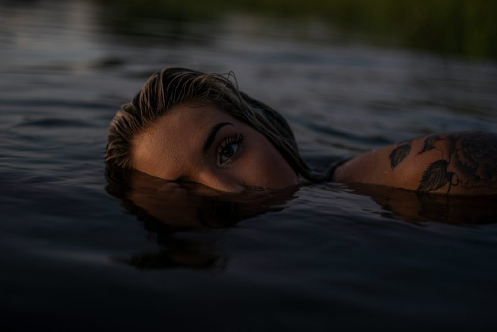 Une femme nage, le visage à moitié immergé
